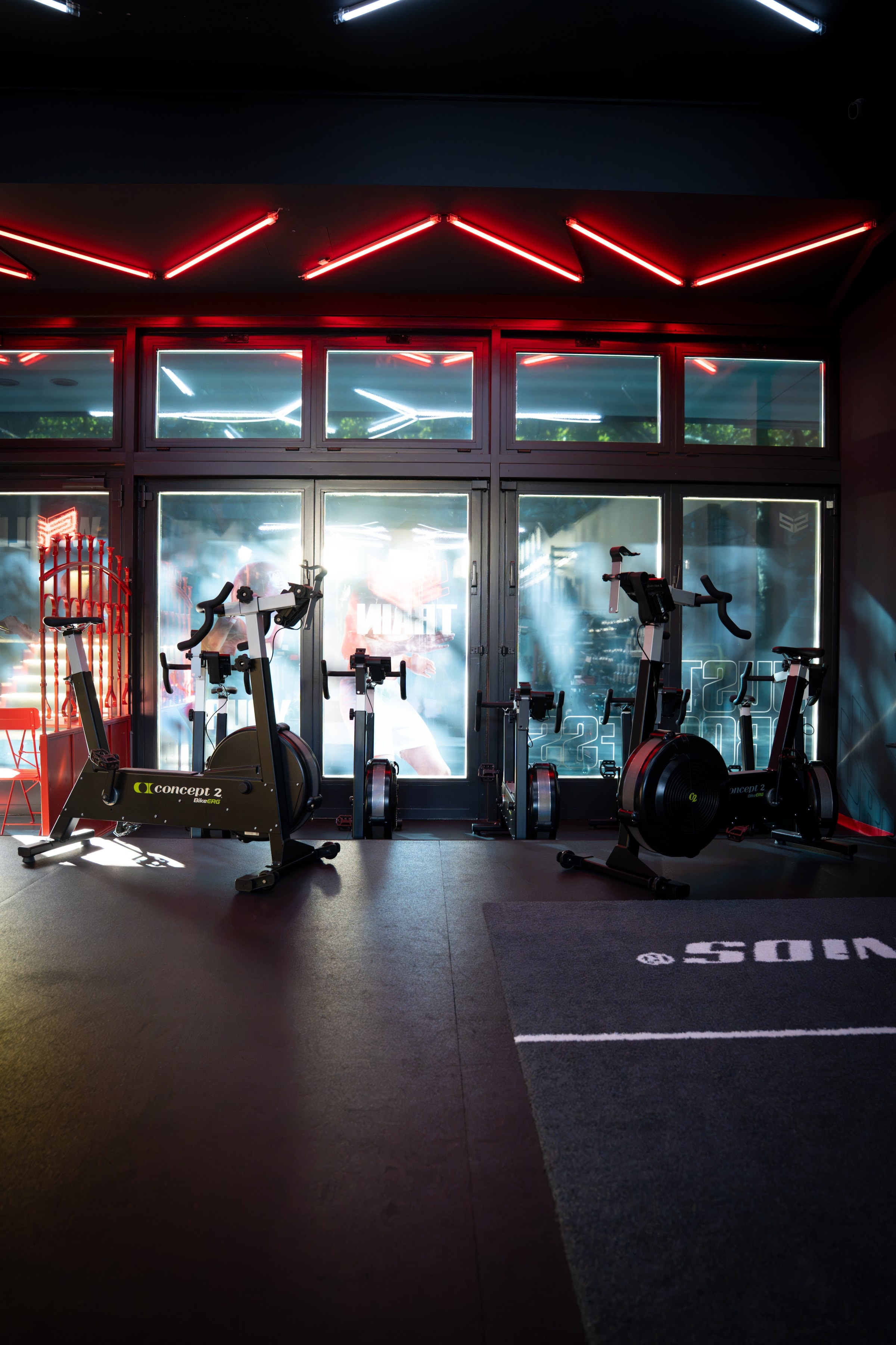 Concept2 BikeErgs vor der Fensterfront mit rotem Neon